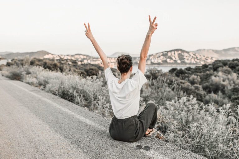 Frau streckt Hände in die Höhe in Freiheit